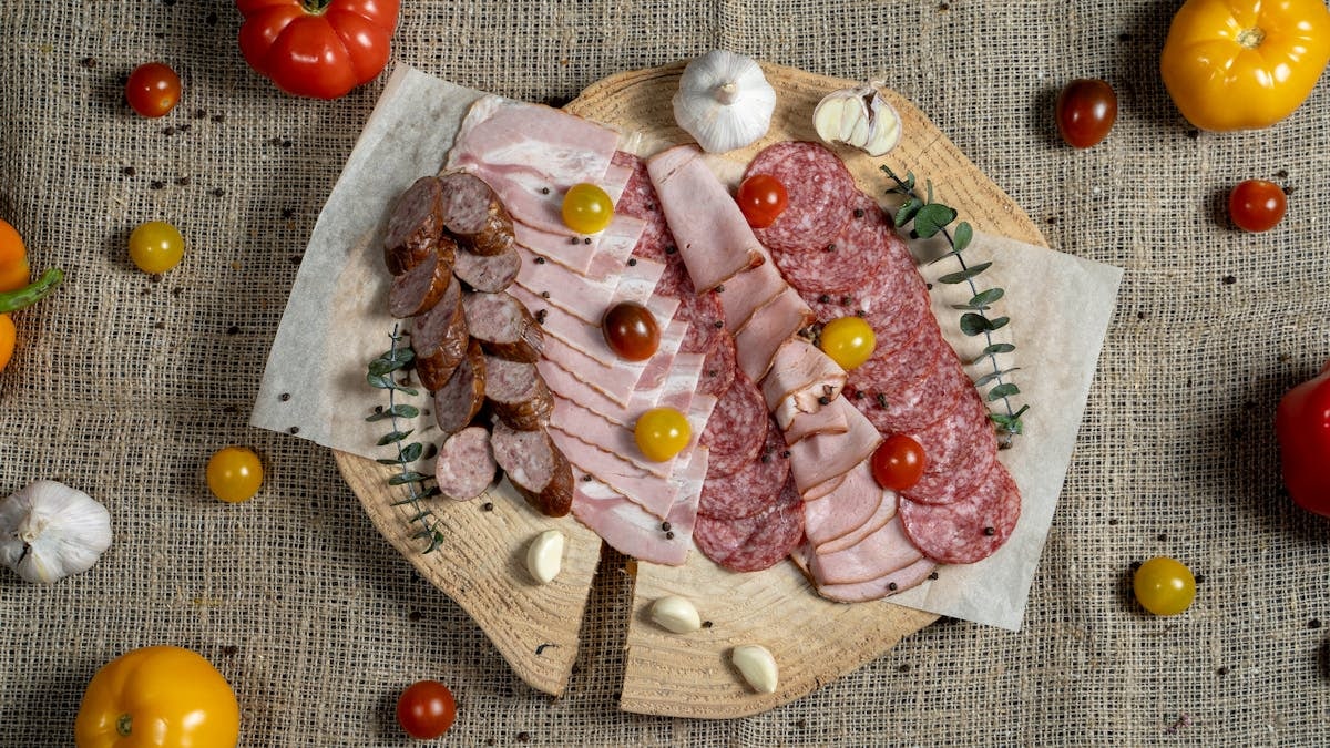 A flavorful assortment of meats and vegetables displayed on a rustic board.