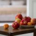 A cozy indoor still life with fresh fruits displayed on a wooden table.